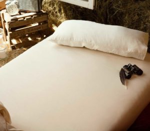 Spannbettlaken auf Matratze im Heuboden